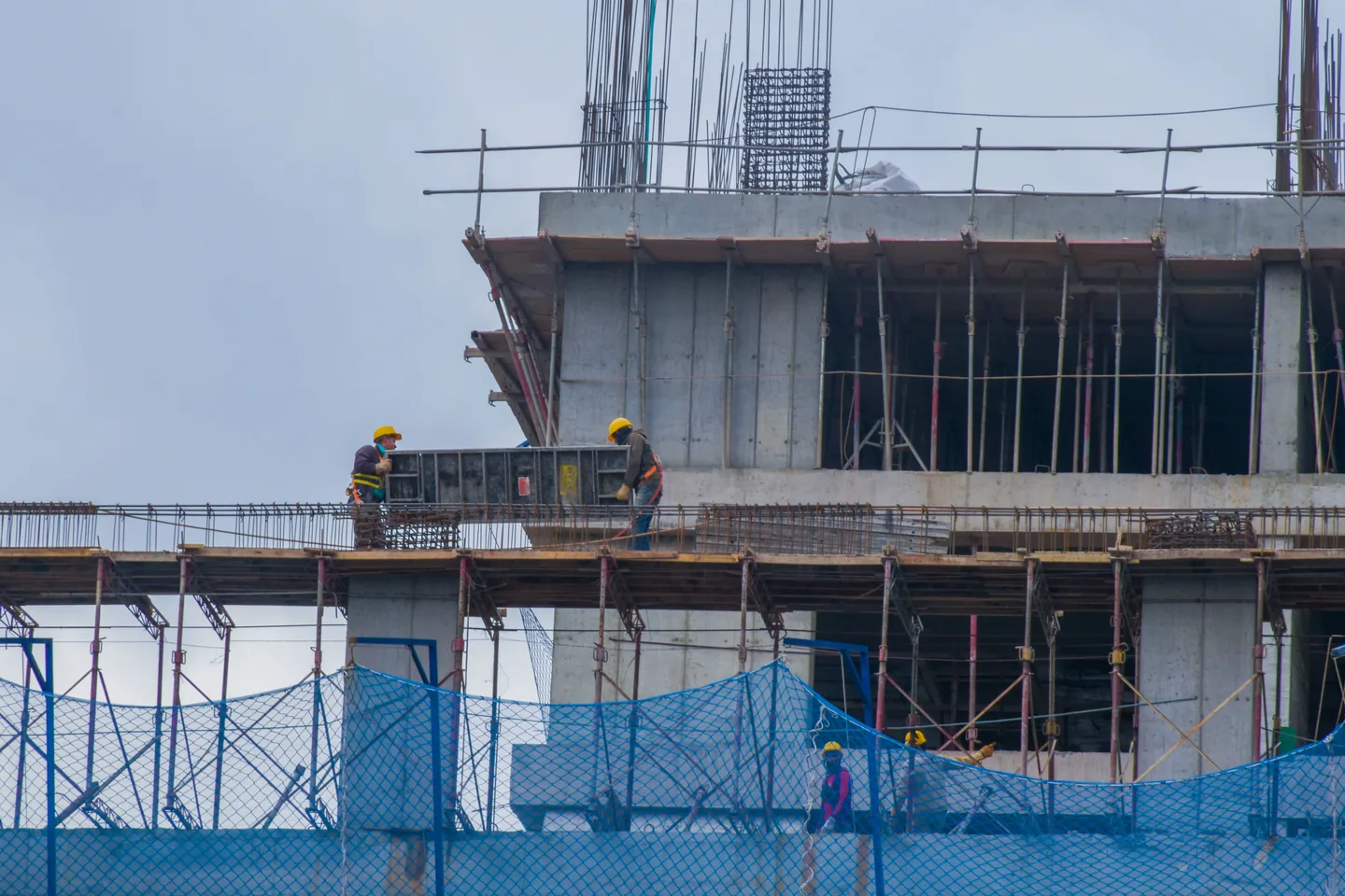 A building under construction, scaffolding against the frame