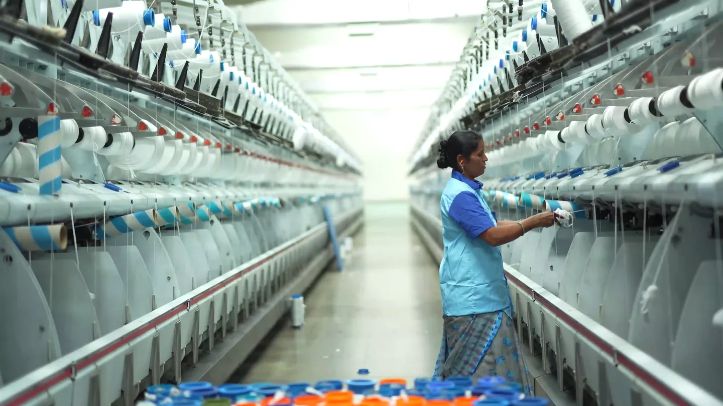 A worker operating cotton spinning machines in a mill