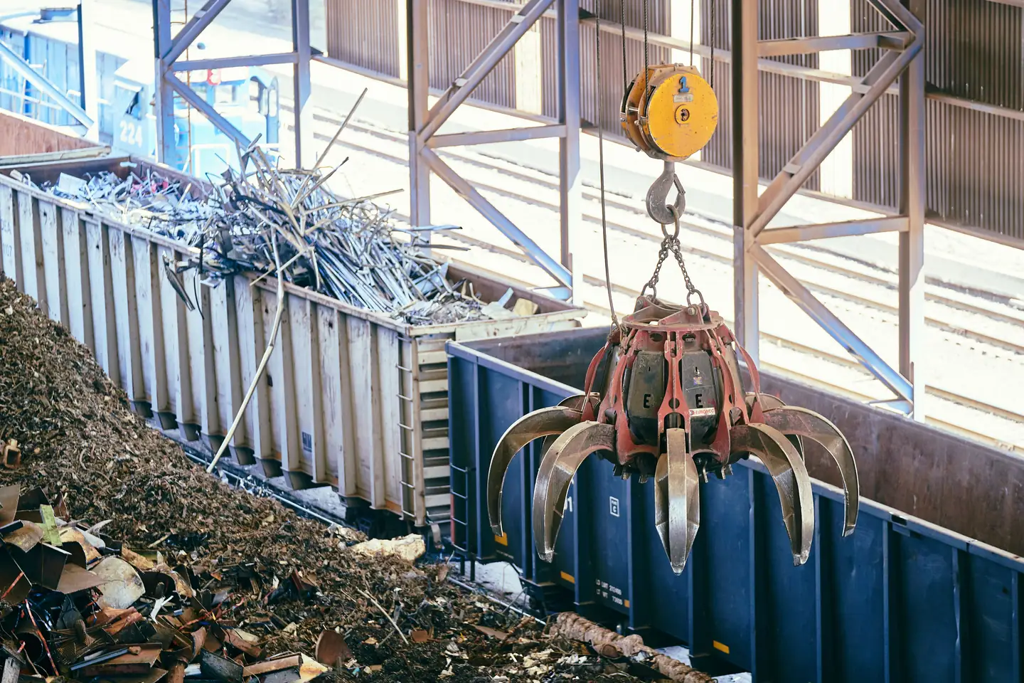 An overhead crane sorting scrap metal at a recycling plant