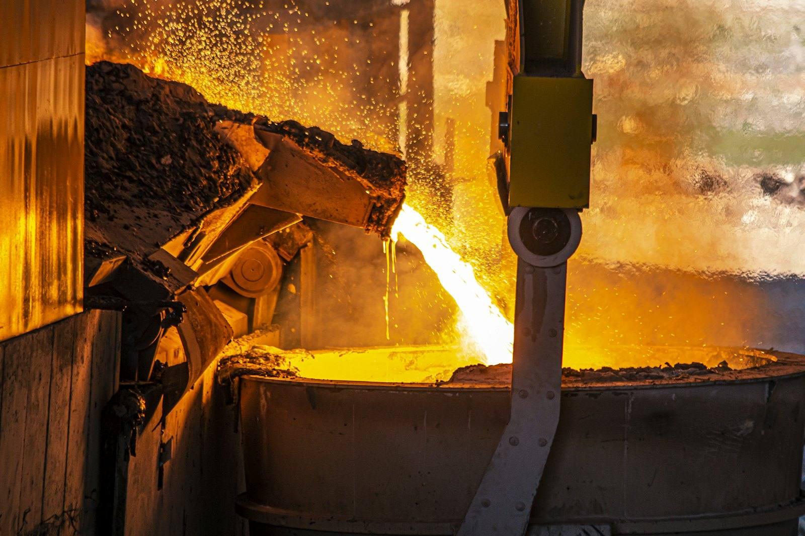 Molten metal pouring from a furnace into an industrial ladle
